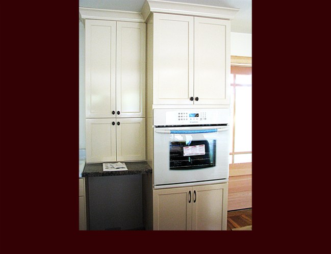 Full height oven appliance cabinet with pantry storage. Tall upper pantry cabinet over dishwasher.