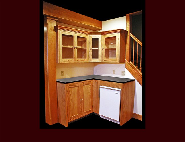 Custom Oak Kitchenette. Flat Panel door style. Glass door upper cabinets. Crown Moulding.