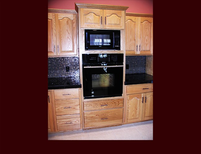 Custom Oak Kitchen Remodel. Raised Panel Cathedral door style. Full height wall oven cabinet with full extension pots & pans drawers and upper storage. Crown Moulding.